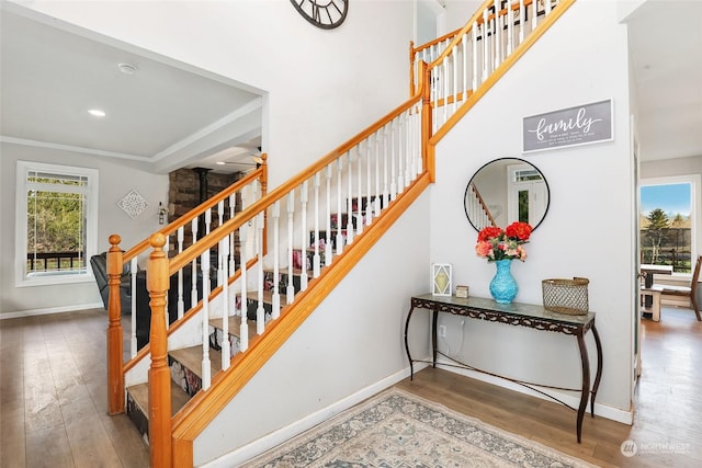 stairway featuring hardwood / wood-style floors and crown molding