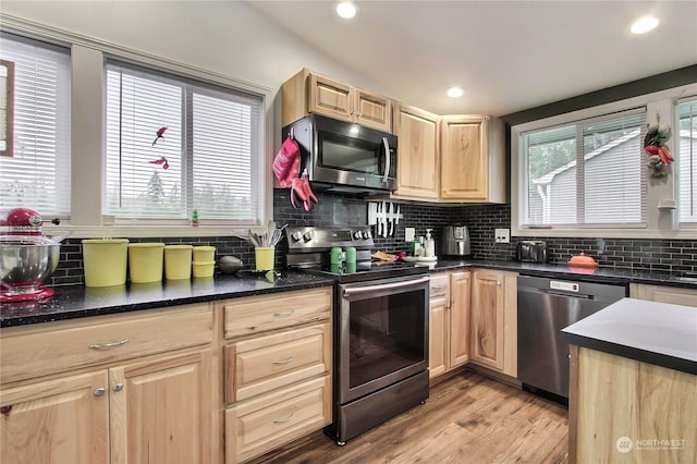 kitchen with light brown cabinets, light hardwood / wood-style flooring, stainless steel appliances, and a healthy amount of sunlight