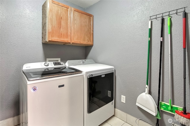 laundry room with cabinets, light tile patterned floors, and independent washer and dryer