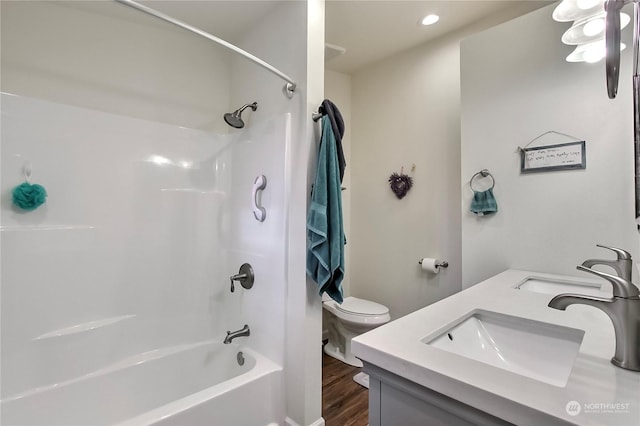 full bathroom featuring wood-type flooring, toilet, vanity, and  shower combination