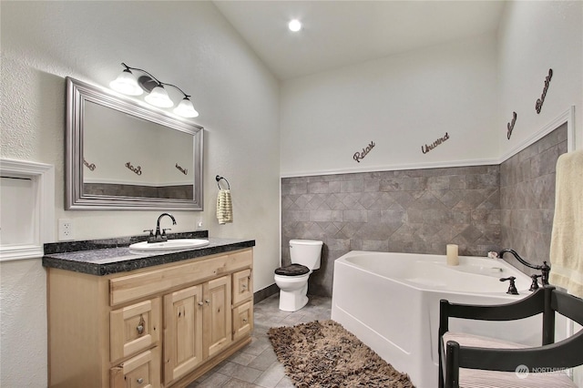 bathroom featuring toilet, a bathing tub, tile patterned flooring, tile walls, and vanity