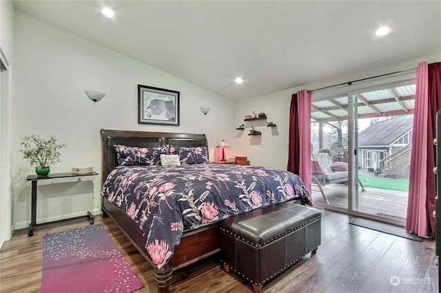 bedroom with hardwood / wood-style floors, access to outside, and vaulted ceiling