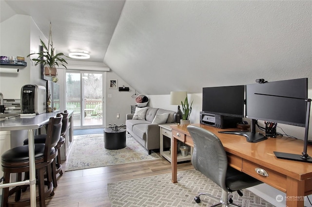 office area featuring lofted ceiling and light hardwood / wood-style flooring