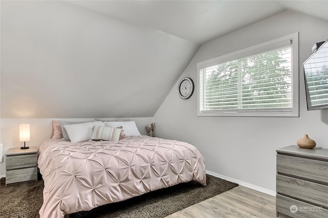 bedroom with vaulted ceiling and hardwood / wood-style floors