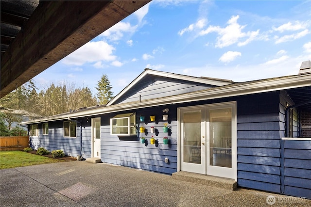 exterior space with a patio area, fence, and french doors