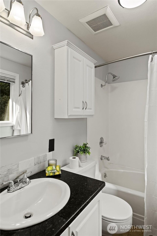 full bath featuring toilet, vanity, visible vents, and shower / tub combo with curtain