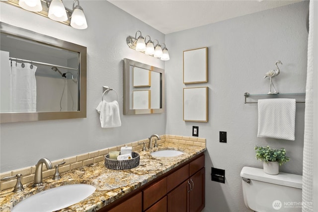 bathroom featuring toilet, double vanity, a sink, and a shower with shower curtain