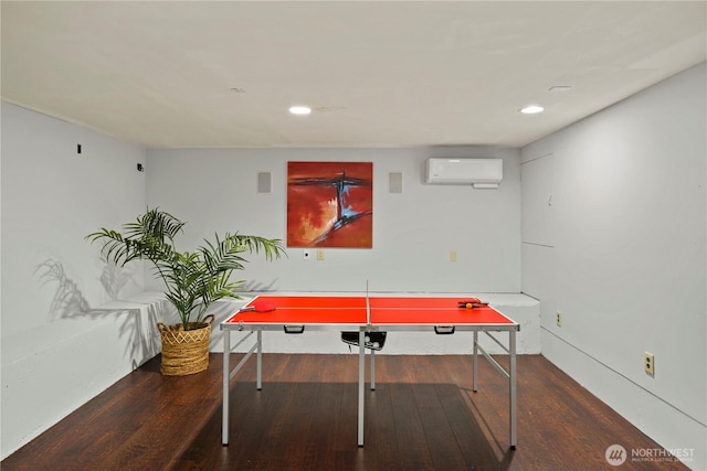 game room with recessed lighting, an AC wall unit, and wood finished floors