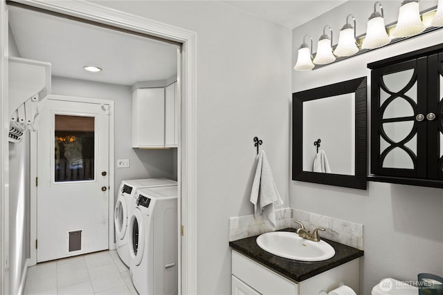 laundry area with cabinet space, washing machine and dryer, light tile patterned floors, and a sink