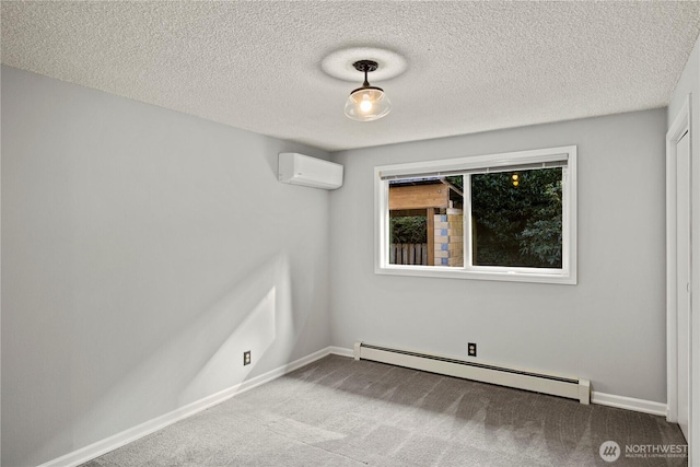 spare room featuring a baseboard heating unit, a wall unit AC, carpet floors, and baseboards