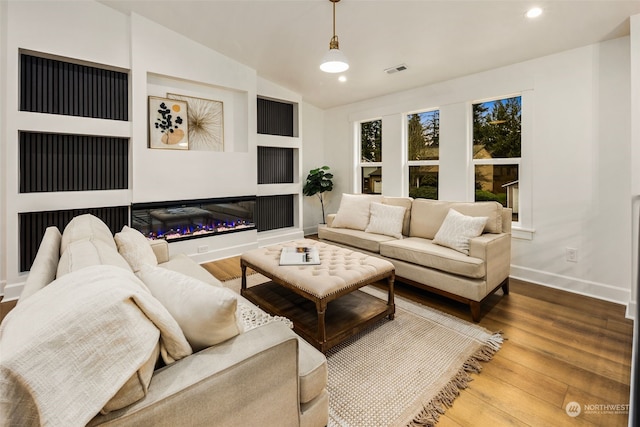 living room with vaulted ceiling and wood-type flooring