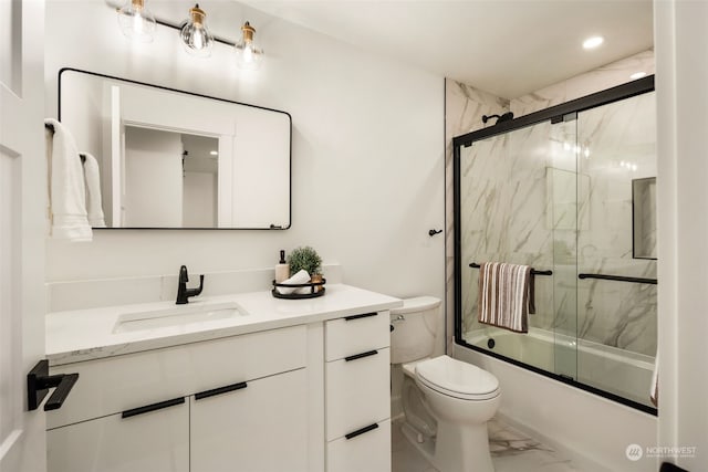 full bathroom featuring toilet, bath / shower combo with glass door, and vanity