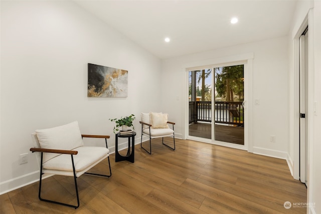 living area with wood-type flooring and vaulted ceiling