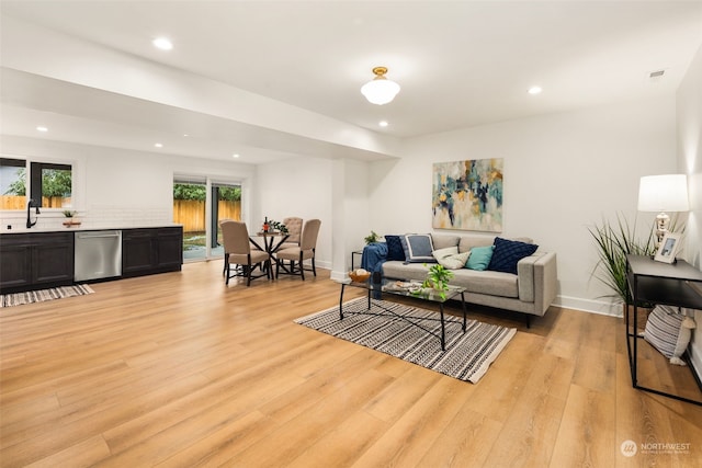 living room featuring light wood-type flooring and sink