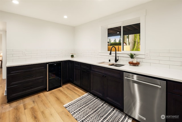 kitchen with light hardwood / wood-style floors, tasteful backsplash, wine cooler, stainless steel dishwasher, and sink