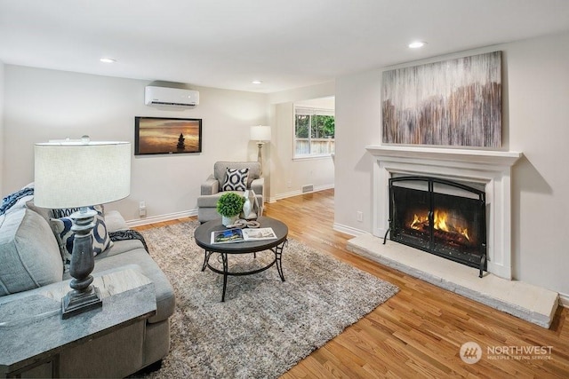 living room with a wall mounted AC and hardwood / wood-style flooring