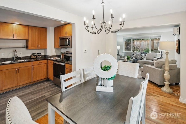 dining space with sink, a wall mounted AC, dark hardwood / wood-style flooring, and a chandelier