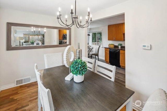 dining area with hardwood / wood-style flooring and a notable chandelier