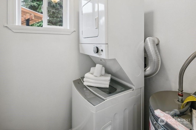 washroom featuring stacked washer and clothes dryer and water heater