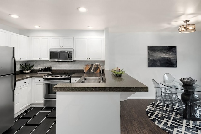 kitchen featuring a kitchen bar, sink, white cabinetry, and appliances with stainless steel finishes