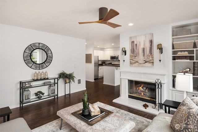 living room featuring ceiling fan and dark wood-type flooring