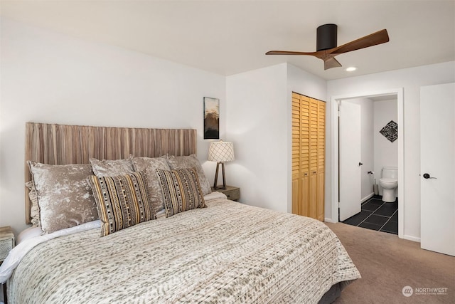 carpeted bedroom featuring ceiling fan, a closet, and ensuite bath