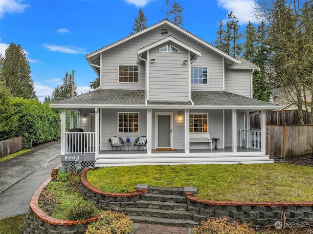 back of property with a yard and a porch