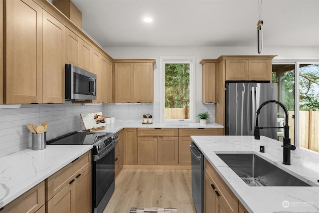 kitchen with sink, a wealth of natural light, appliances with stainless steel finishes, and tasteful backsplash