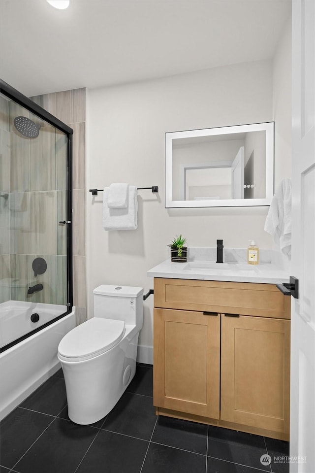 full bathroom with toilet, enclosed tub / shower combo, tile patterned flooring, and vanity