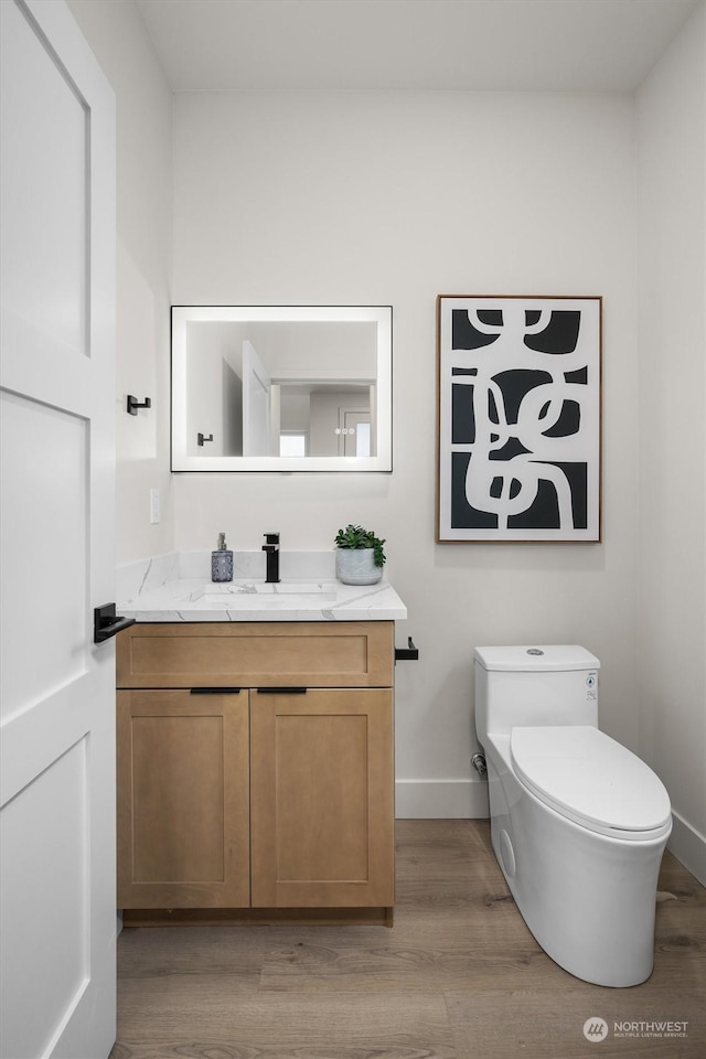 bathroom with hardwood / wood-style floors, toilet, and vanity