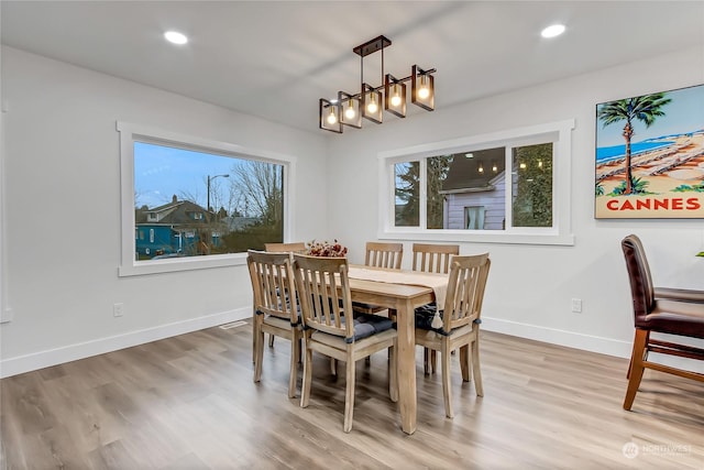 dining space featuring an inviting chandelier and light wood-type flooring