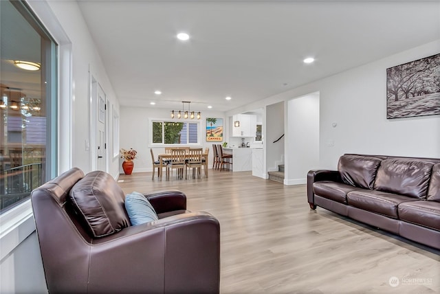 living room with an inviting chandelier and light wood-type flooring