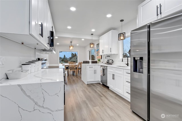 kitchen featuring white cabinets, pendant lighting, appliances with stainless steel finishes, and sink