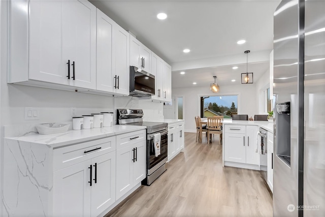 kitchen featuring white cabinets, appliances with stainless steel finishes, light hardwood / wood-style floors, hanging light fixtures, and light stone counters