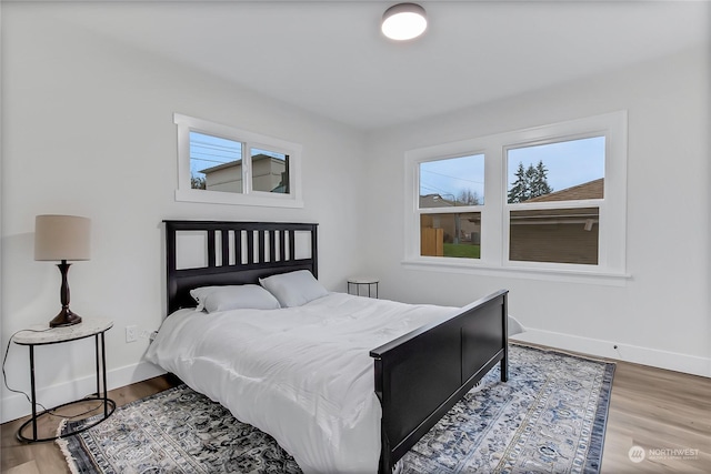 bedroom featuring multiple windows and hardwood / wood-style floors