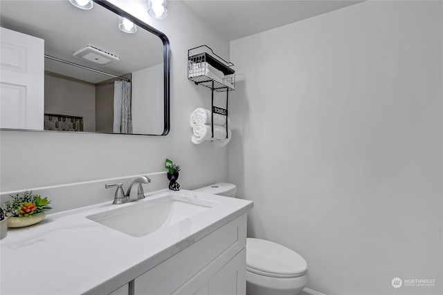 bathroom with toilet, vanity, and a shower with curtain