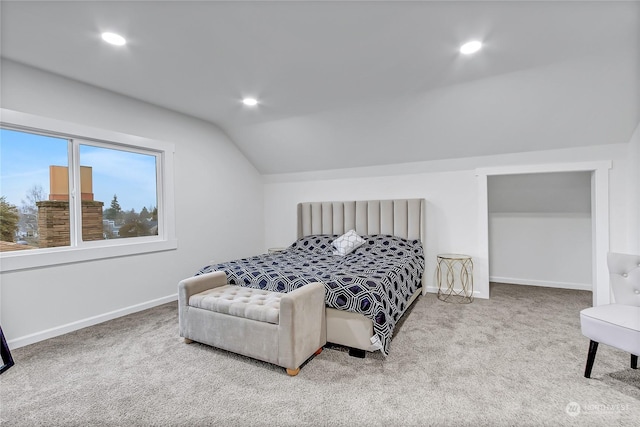 bedroom featuring lofted ceiling and light carpet