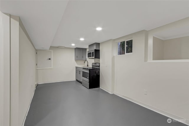 kitchen featuring concrete flooring, appliances with stainless steel finishes, gray cabinetry, and sink