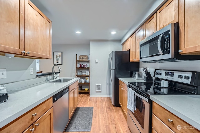 kitchen featuring stainless steel appliances, light hardwood / wood-style floors, and sink