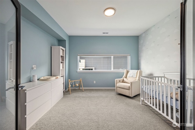 carpeted bedroom featuring a crib