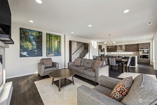 living room featuring sink, hardwood / wood-style floors, and an inviting chandelier