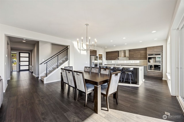 dining room featuring sink, a notable chandelier, and dark hardwood / wood-style flooring