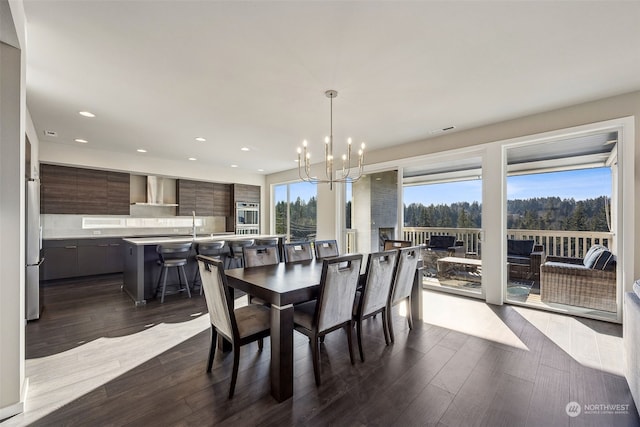 dining room with sink, a chandelier, and dark hardwood / wood-style flooring