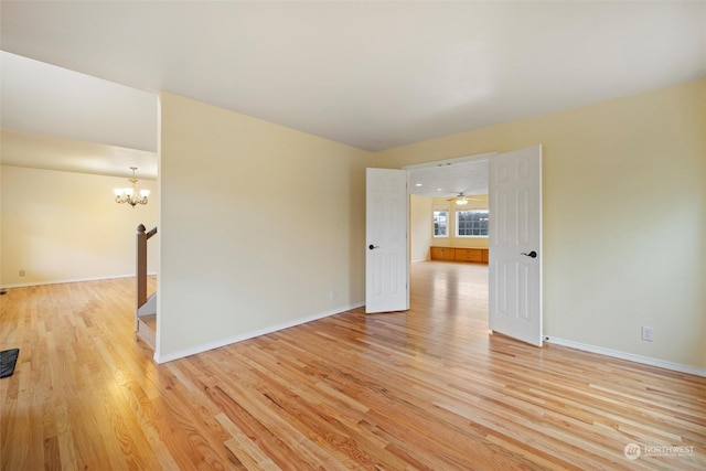 unfurnished room featuring light hardwood / wood-style floors and an inviting chandelier