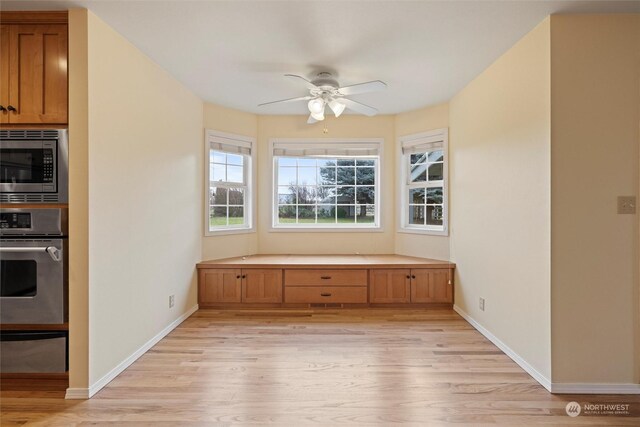 unfurnished dining area featuring ceiling fan and light wood-type flooring