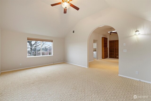 carpeted spare room featuring ceiling fan, washer / dryer, and vaulted ceiling