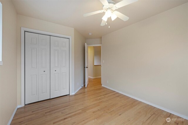 unfurnished bedroom featuring ceiling fan, light hardwood / wood-style floors, and a closet