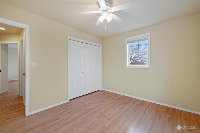 unfurnished bedroom featuring light hardwood / wood-style floors, a closet, and ceiling fan