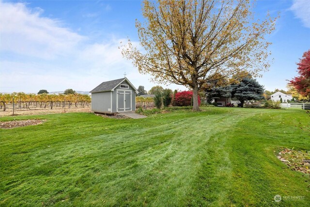 view of yard featuring a rural view and a storage unit