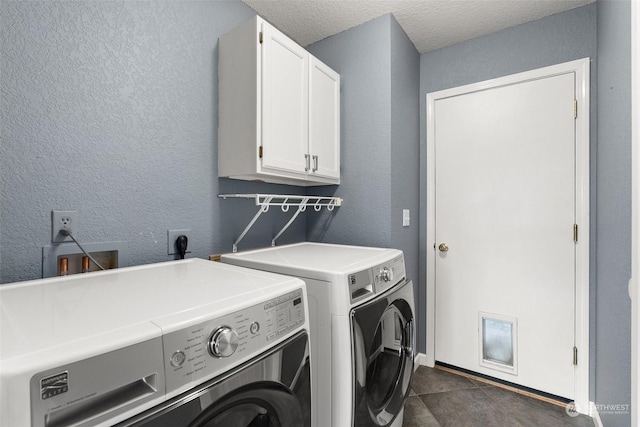 laundry room featuring a textured ceiling, cabinets, and washer and dryer